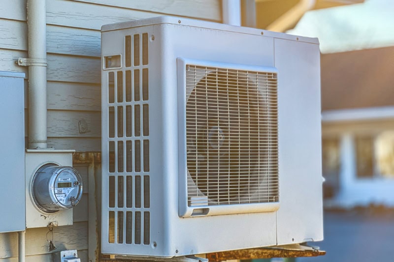 An older heat pump outside of a home